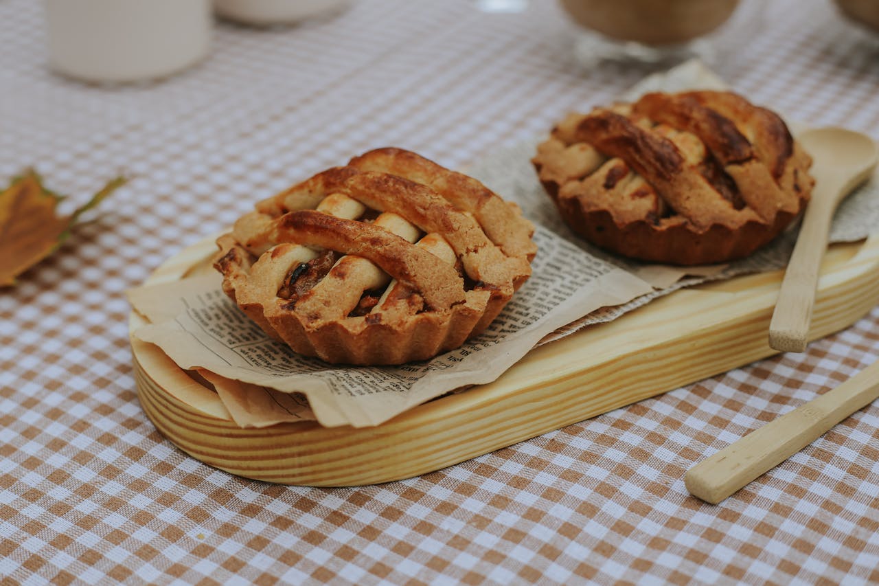 Two rustic mini apple pies served on a wooden board, perfect for autumn picnics.